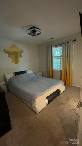 a bedroom with a bed and a painting on the wall