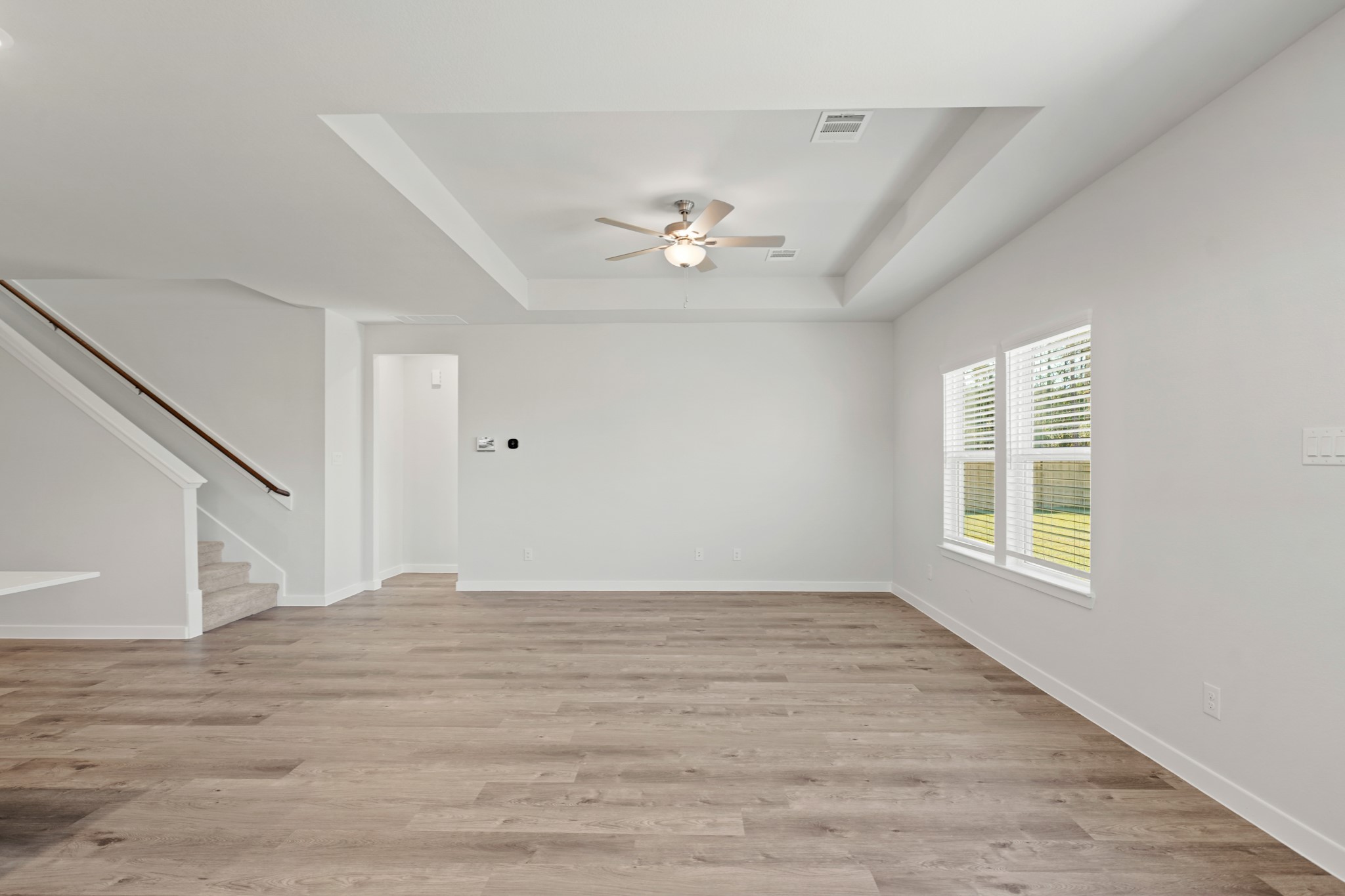 9798 Caney Bend Road Conroe, TX 77303 - Photo 16 of 27 a view of an empty room with chandelier fan and wooden floor