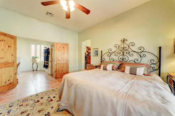 a spacious bedroom with a bed and a flat screen tv