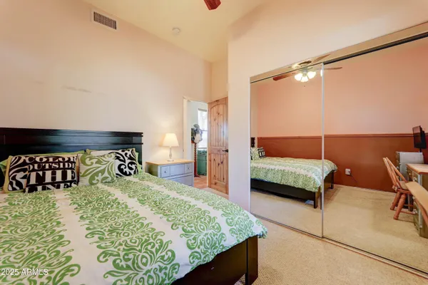 a bed sitting in a bedroom next to a window with a chandelier