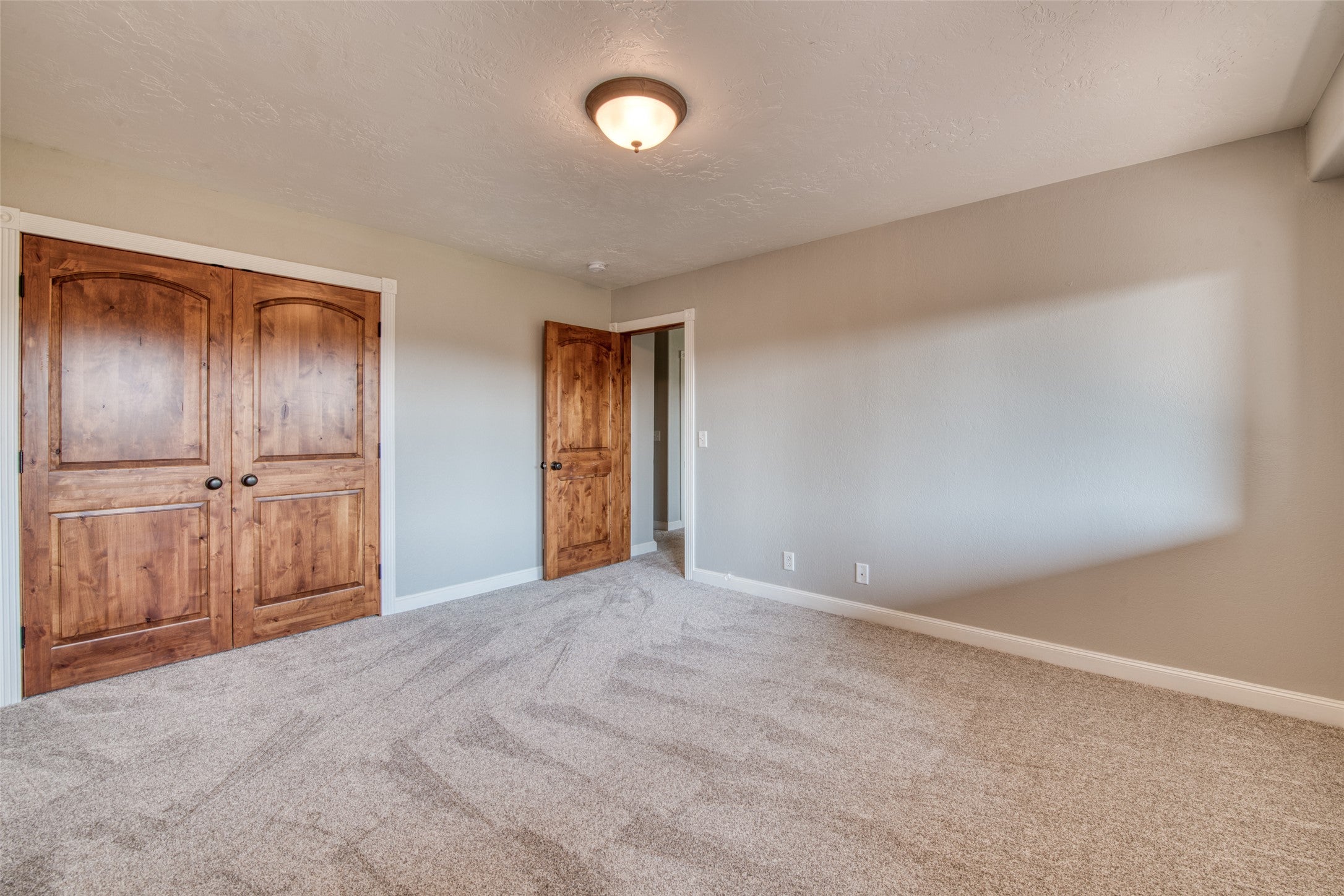 16374 Folsom Road Florence, MT 59833 - Photo 93 of 98 Unfurnished bedroom with carpet flooring, a closet, and a textured ceiling