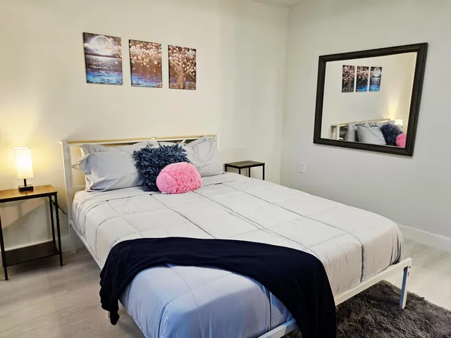 a bedroom with a bed and a painting on the wall