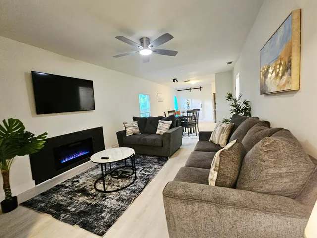 a living room with furniture a fireplace and a flat screen tv