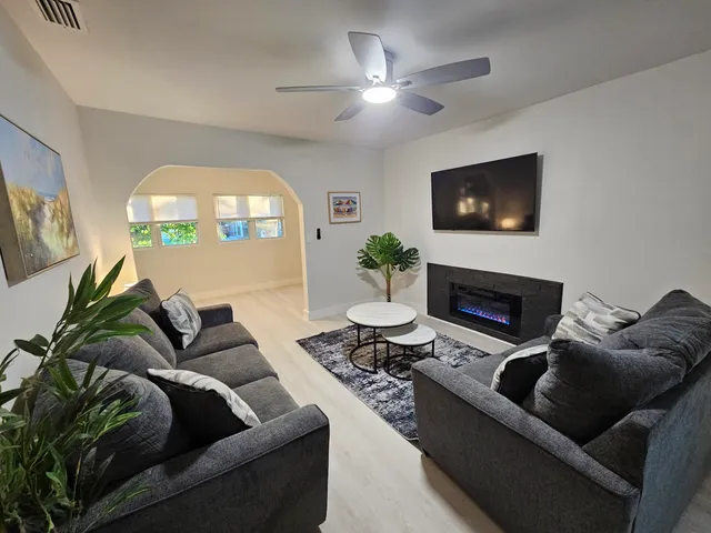 a living room with furniture a fireplace and a flat screen tv