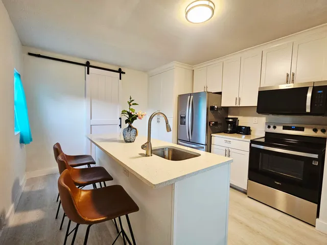a kitchen with stainless steel appliances a stove a sink and a refrigerator