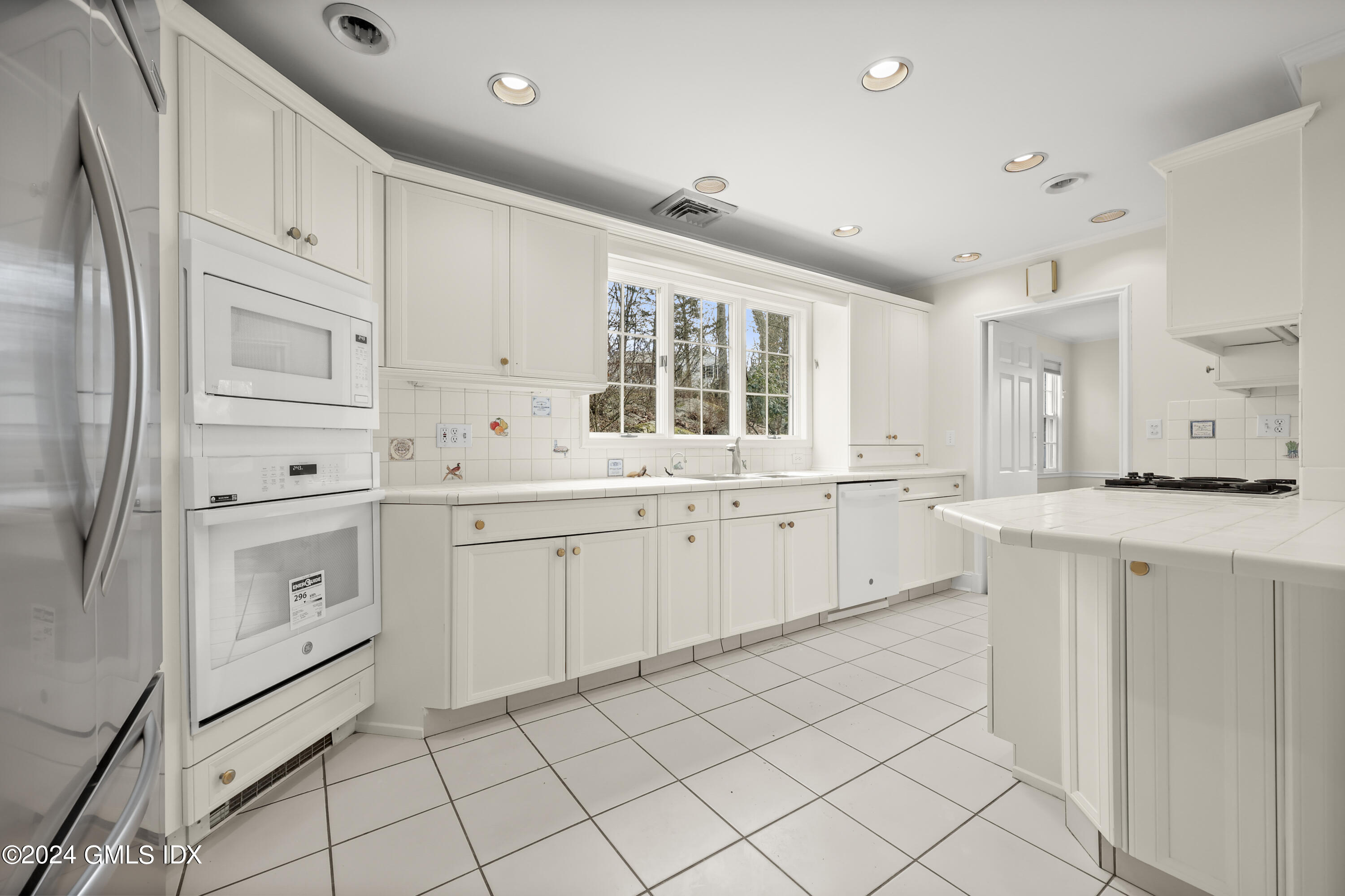 320 Cognewaugh Road Cos Cob, CT 06807 - Photo 6 of 15 a kitchen with white cabinets and white appliances