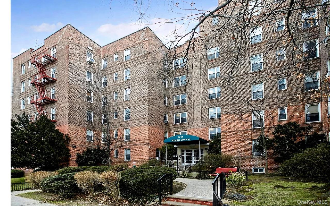 84-35 Lander Street, Unit 2B Queens, NY 11435 - Photo 16 of 16 a city street lined with tall buildings and a yard