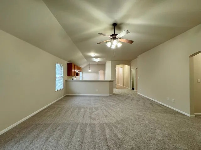 an empty room with a window and a fan