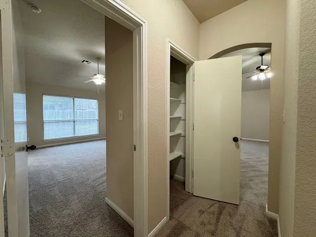 an empty room with a window and a fan