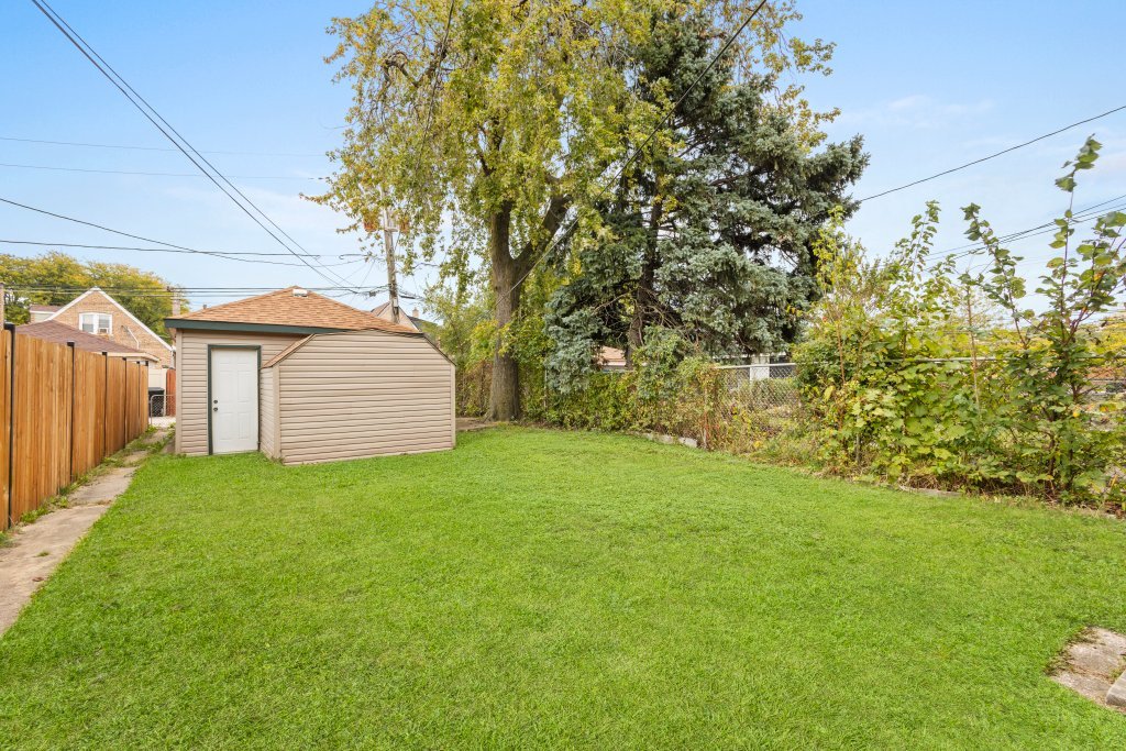 10231 South Rhodes Avenue Chicago, IL 60628 - Photo 25 of 26 a view of a backyard with potted plants and large tree