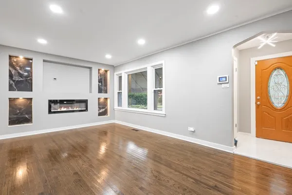 a view of an empty room with a window and fireplace