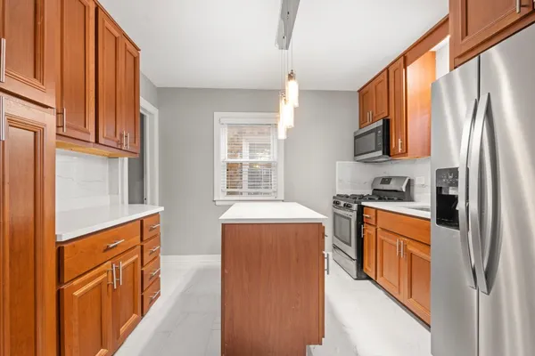 a kitchen with stainless steel appliances granite countertop a refrigerator a stove and a sink