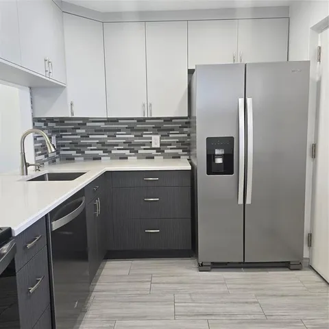 a kitchen with a sink cabinets and stainless steel appliances