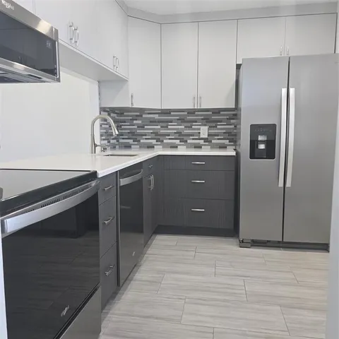 a kitchen with stainless steel appliances granite countertop a refrigerator and a stove
