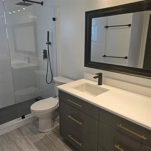 a bathroom with a sink toilet and shower