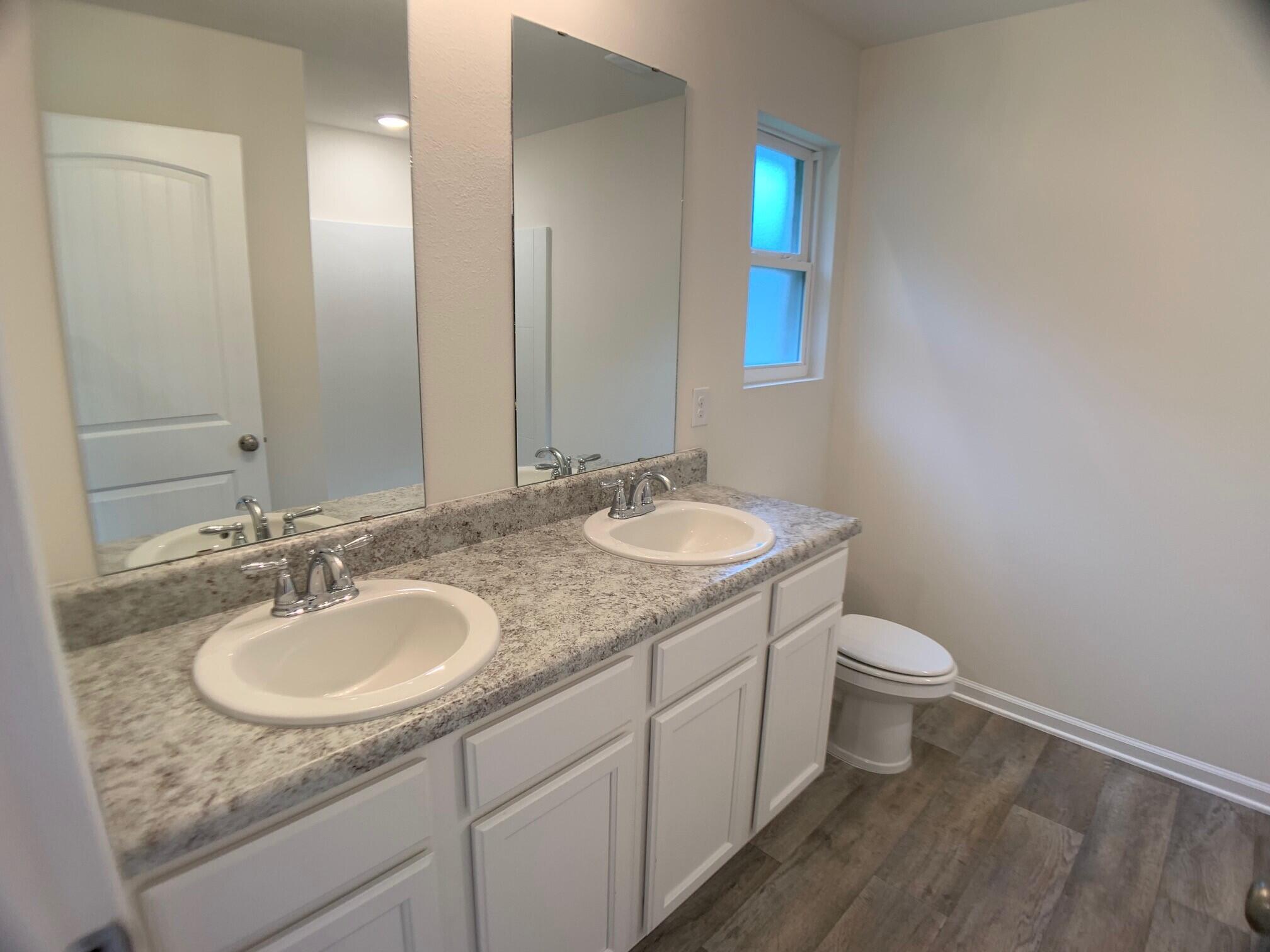 6424 Firefly Drive Milton, FL 32583 - Photo 15 of 33 a bathroom with a granite countertop sink toilet and mirror