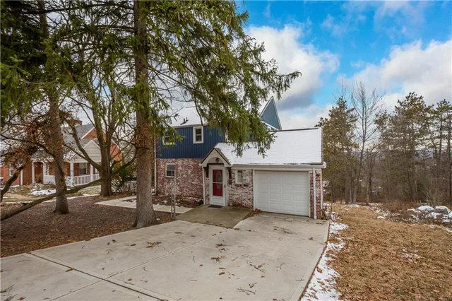 front view of a house with a large tree