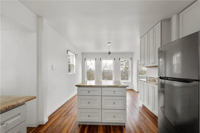 a kitchen with a refrigerator and countertop cabinets