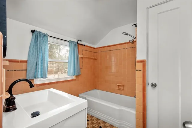 a bathroom with a sink a bathtub and a window