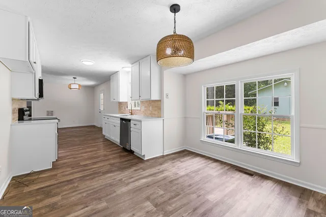 an empty room with windows and ceiling fan