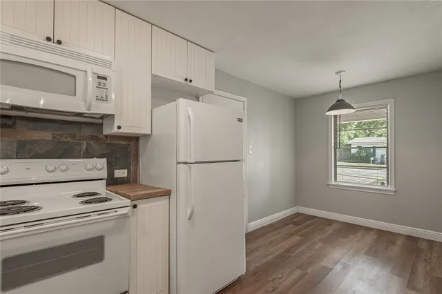 a kitchen with a refrigerator stove and white cabinets