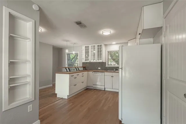 a kitchen with a refrigerator and white cabinets