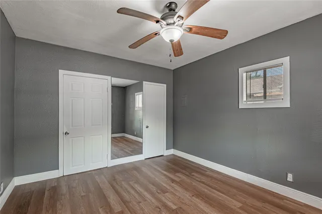 a view of empty room with window and ceiling fan