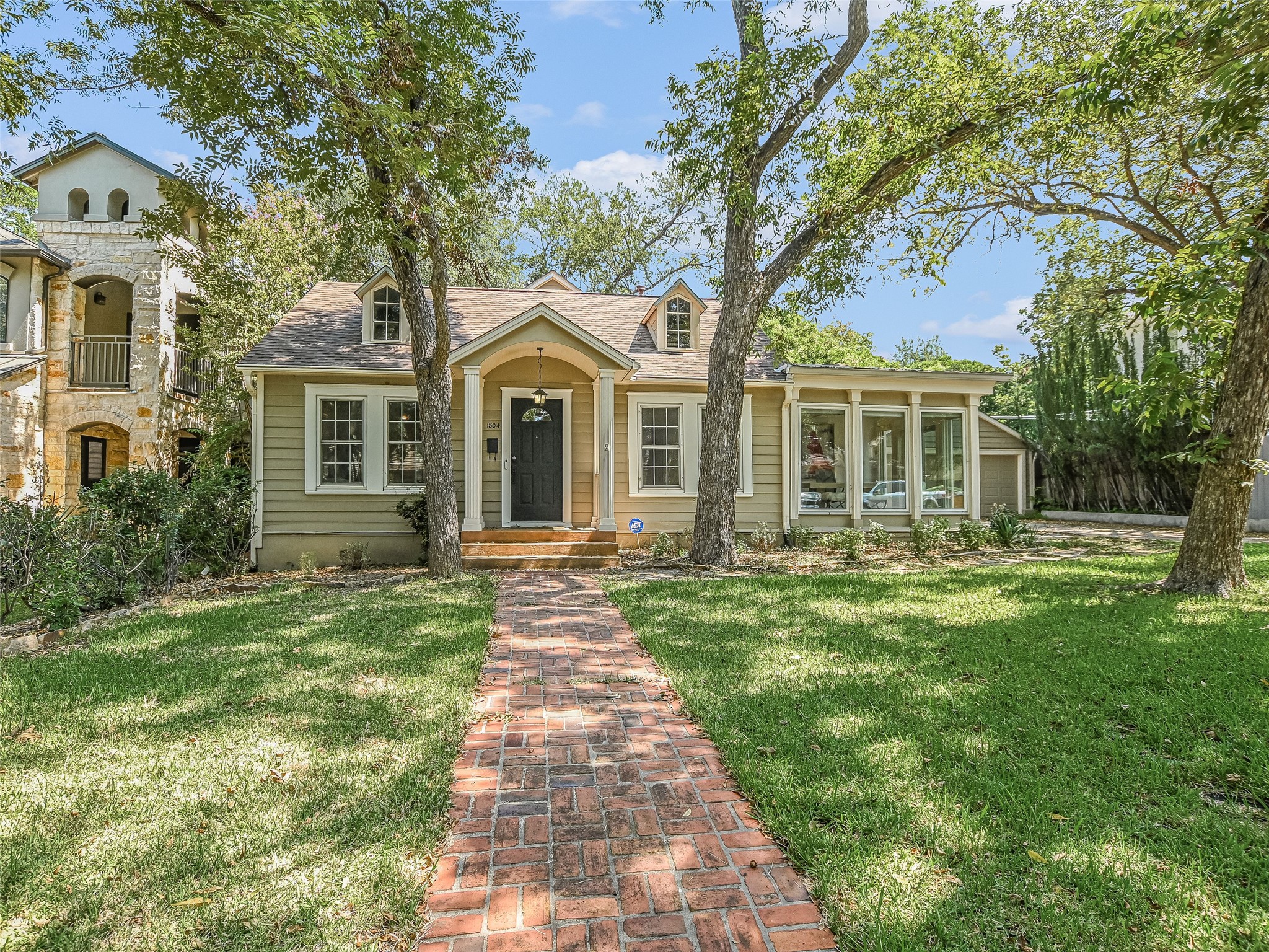 View of front of property featuring a front lawn and a shingled roof