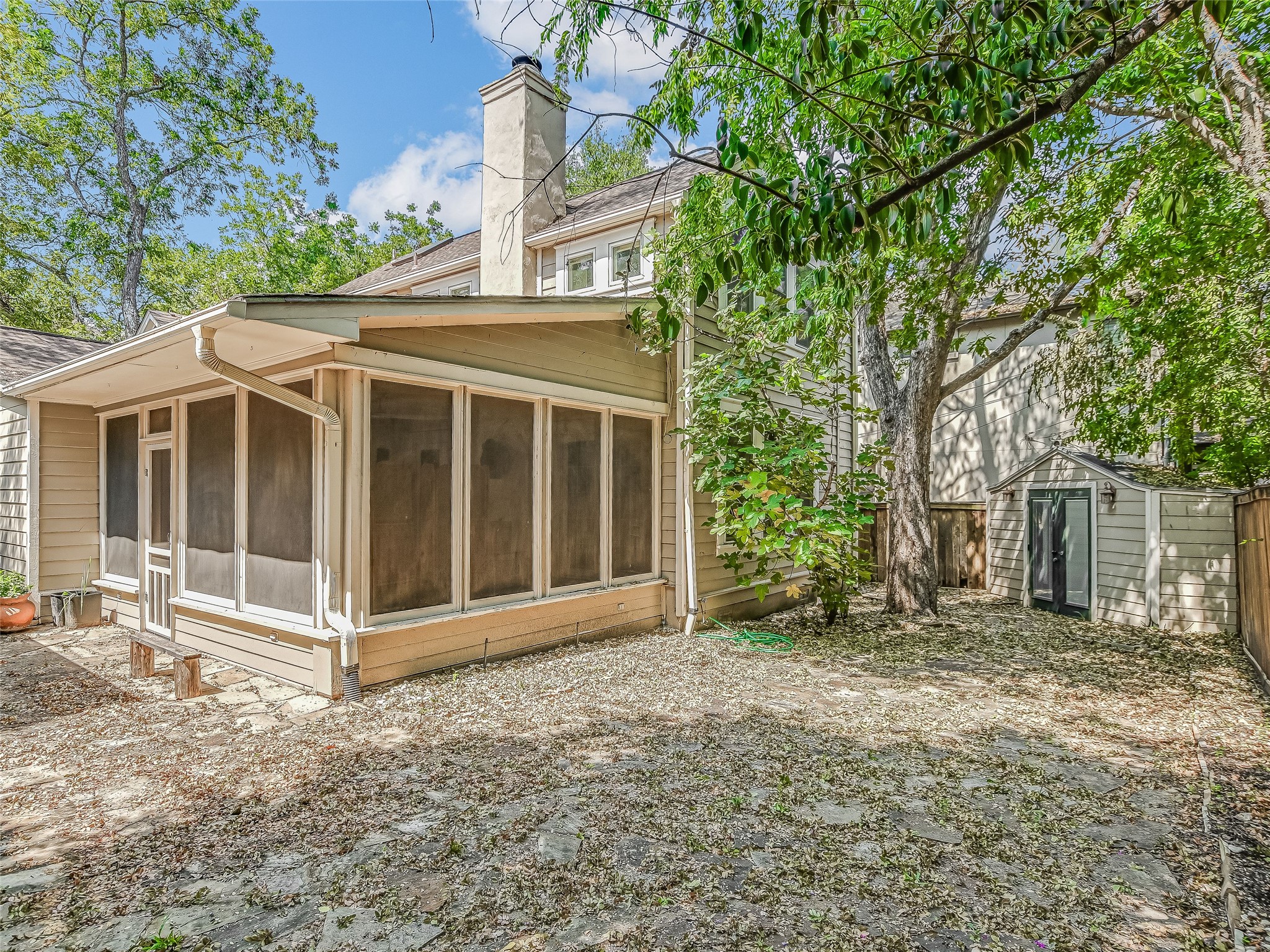 1804 Polo Road Austin, TX 78703 - Photo 17 of 19 Back of property with a sunroom, a storage unit, and a chimney