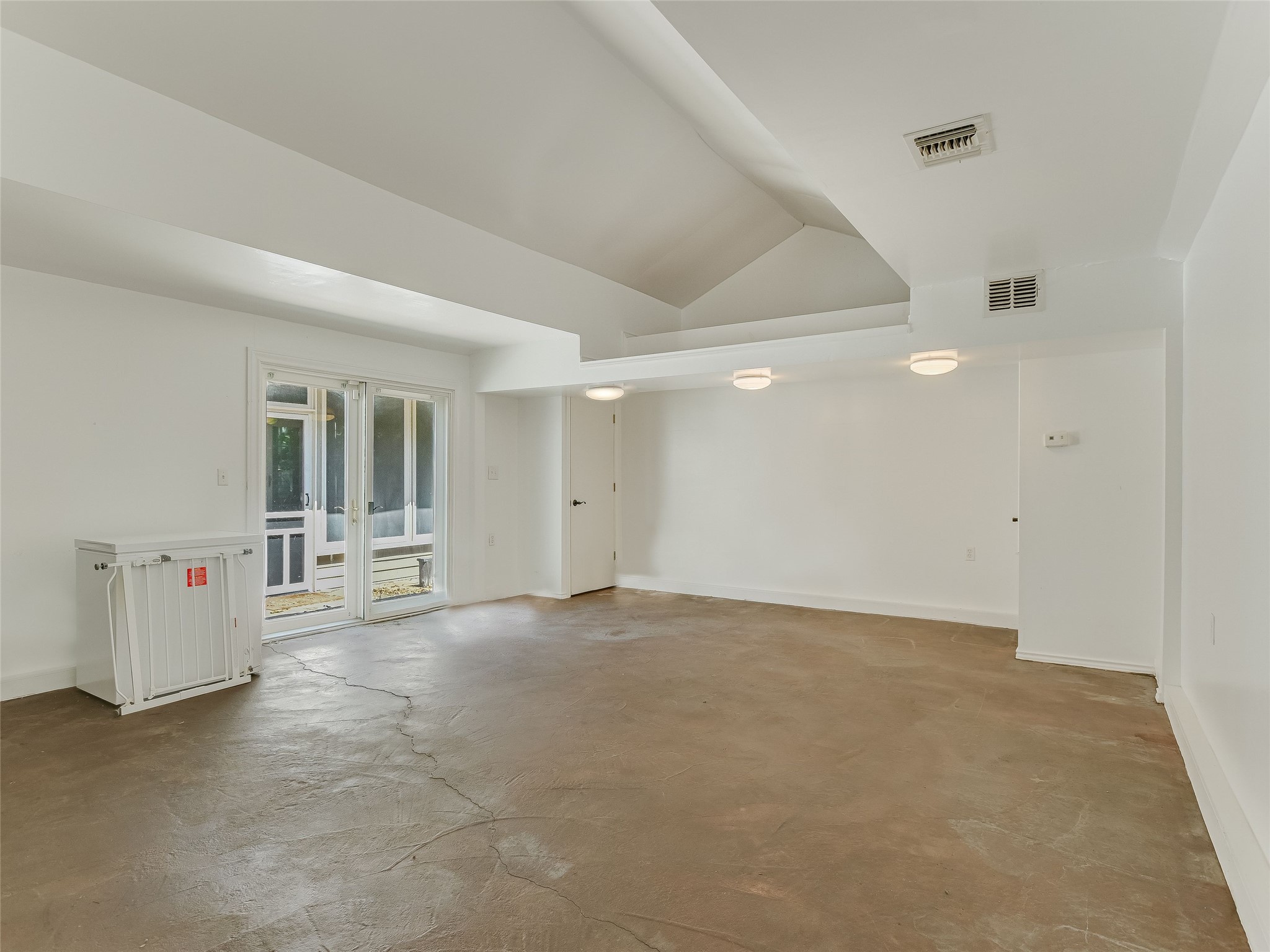1804 Polo Road Austin, TX 78703 - Photo 18 of 19 Unfurnished room with concrete floors, vaulted ceiling, and french doors