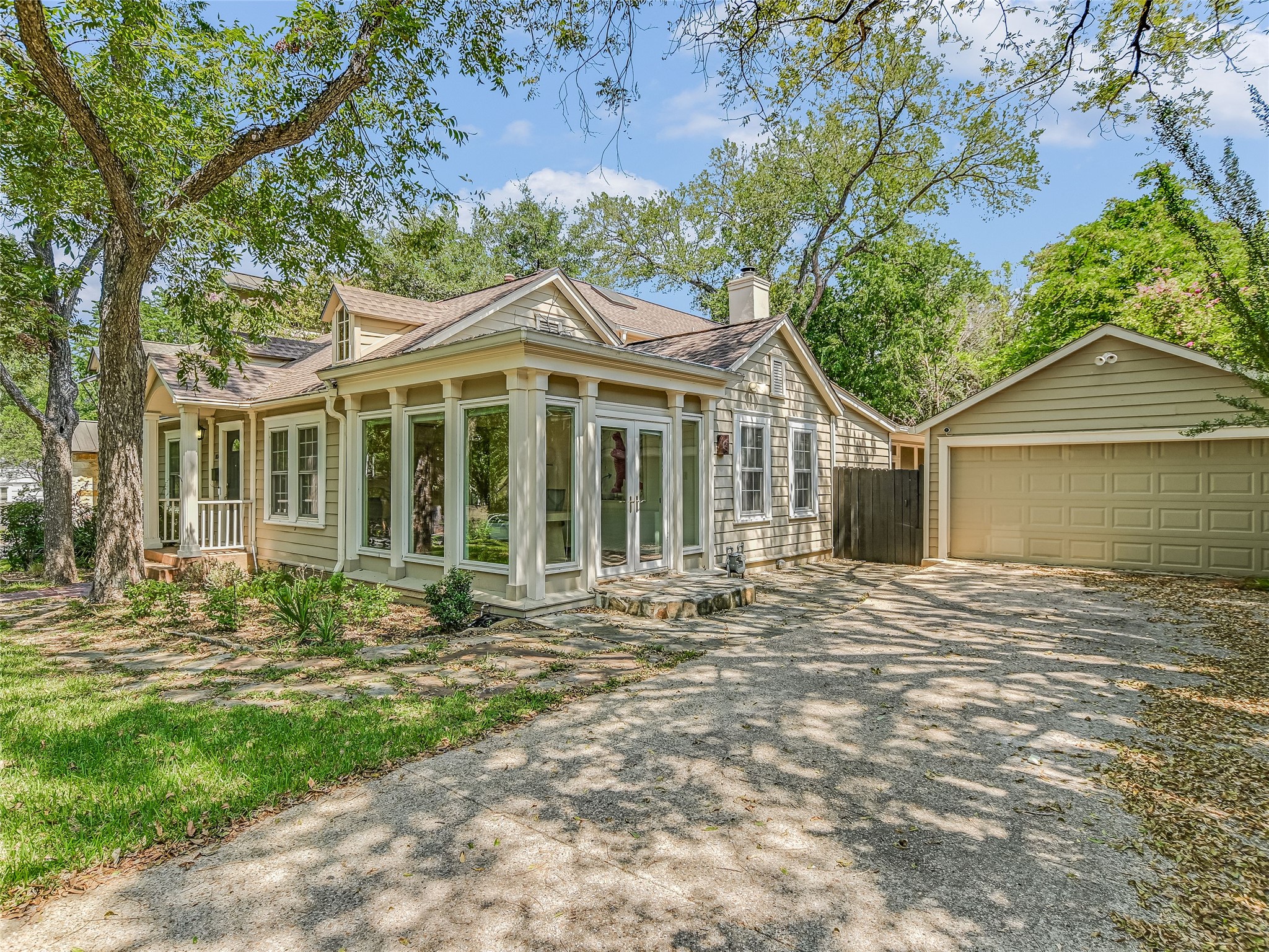 1804 Polo Road Austin, TX 78703 - Photo 2 of 19 View of front of property with a sunroom, an outbuilding, a chimney, a detached garage, and driveway