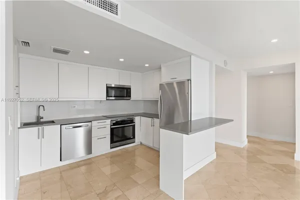 a kitchen with cabinets stainless steel appliances and sink