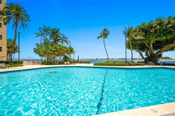 a small pool with trees in the background