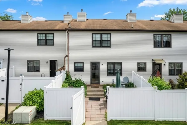 a front view of a house with plants