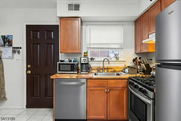 a kitchen with stainless steel appliances a sink stove and refrigerator