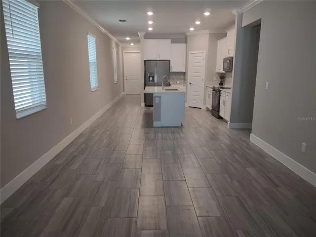 a view of kitchen with wooden floor and electronic appliances