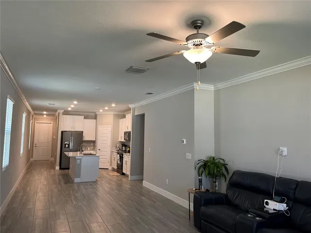 a living room with furniture and kitchen view