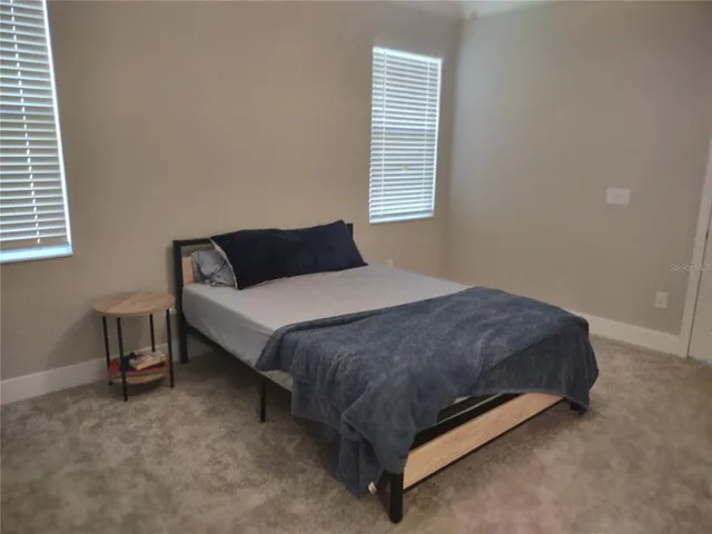 a bedroom with a bed lamp and window