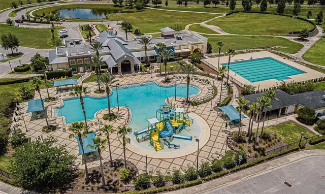 an aerial view of a house with swimming pool and outdoor seating