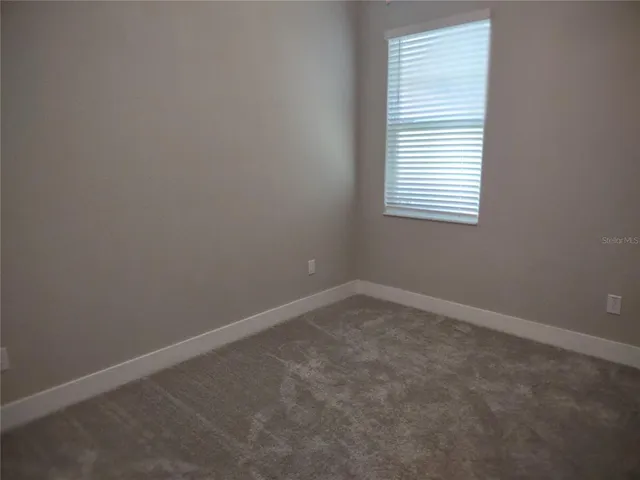 en empty room with a fan and a window