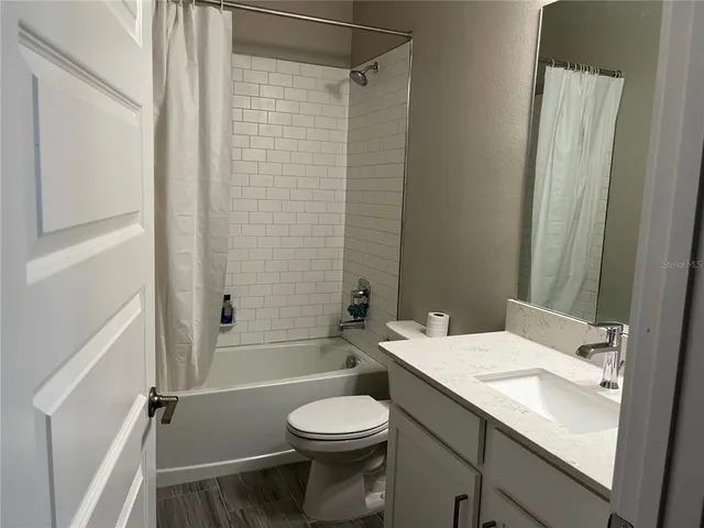 a bathroom with a granite countertop sink a toilet and a large mirror