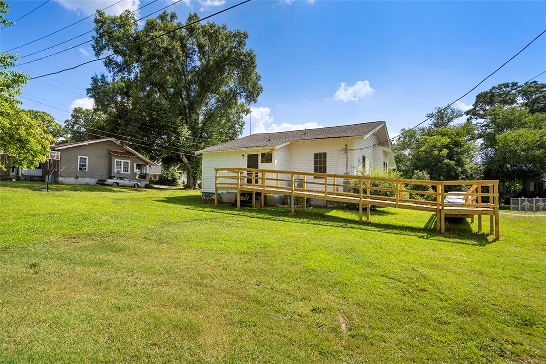 200 Louisiana Street Honea Path, SC 29654 - Photo 11 of 13 A broad, green yard offers ample outdoor space alongside a charming white-sided home.