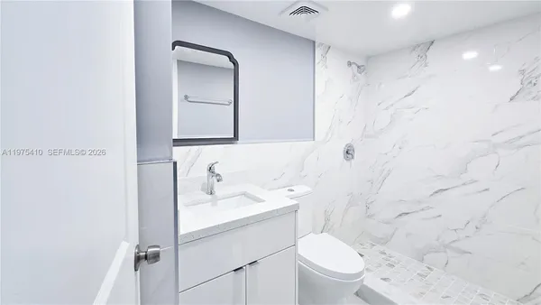 a view of an empty room with window and closet area