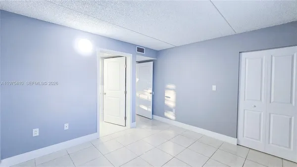 a view of an empty room with window and bathroom