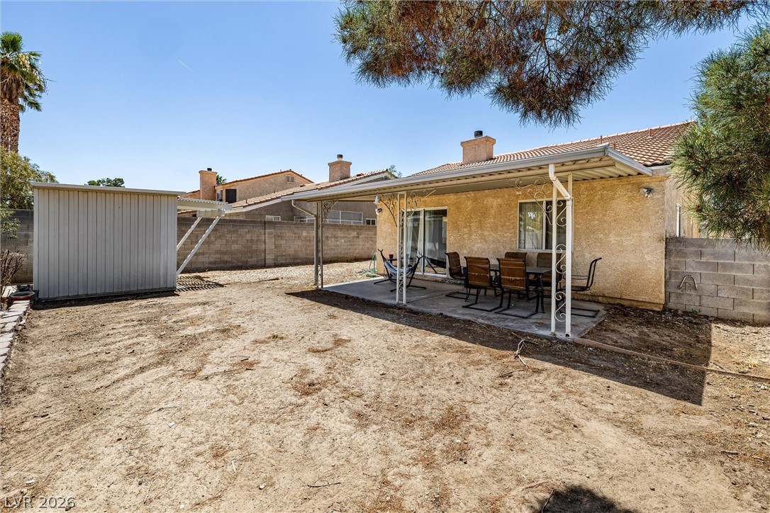 1624 Palmae Way Las Vegas, NV 89128 - Photo 17 of 18 An arid backyard with a covered patio area offers a blank canvas for landscaping dreams.