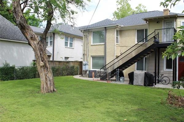 a view of a house with backyard and a tree