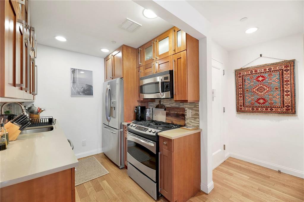 26 4th Street, Unit 2D Brooklyn, NY 11231 - Photo 14 of 26 a kitchen with stainless steel appliances a refrigerator and a stove top oven