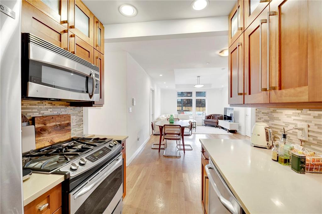 26 4th Street, Unit 2D Brooklyn, NY 11231 - Photo 15 of 26 a kitchen with stainless steel appliances a stove a sink dishwasher and a microwave oven with wooden floor