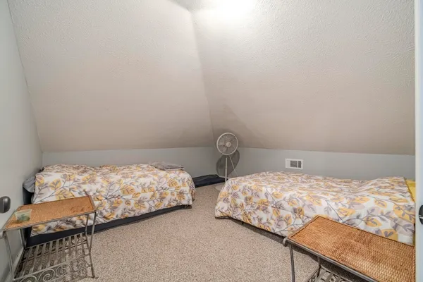 a bedroom with two bed and a window