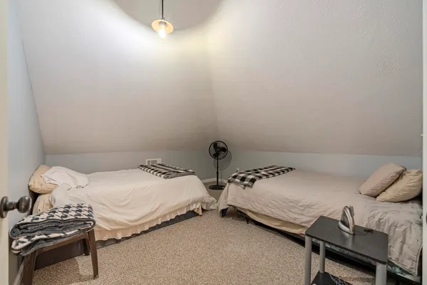 a bedroom with two beds and a chair